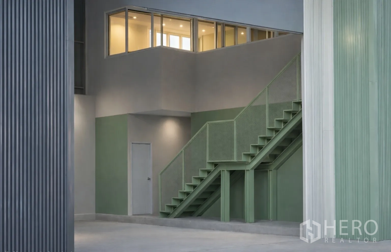 Warehouse for rent in Bang Kapi, Bangkok - Close-up of the metal staircase and mezzanine offices with large interior windows.