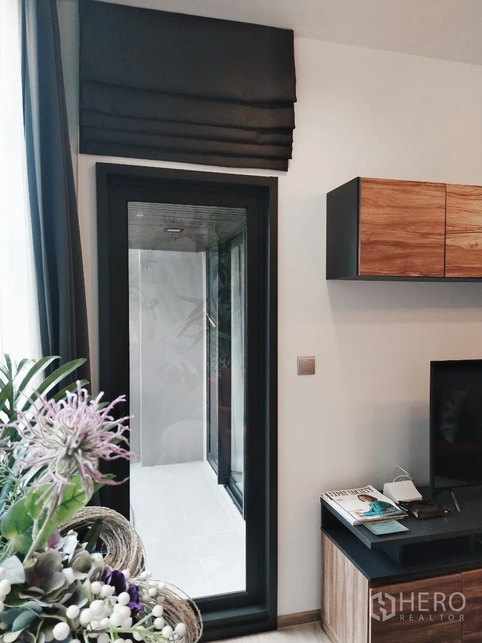 公寓 for rent in Watthana, Bangkok - 客厅侧门通往阳台，配罗马帘与电视柜。
