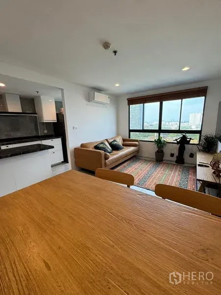 Condominium for rent or sale - Open-plan living with kitchen and a large window providing green city views.