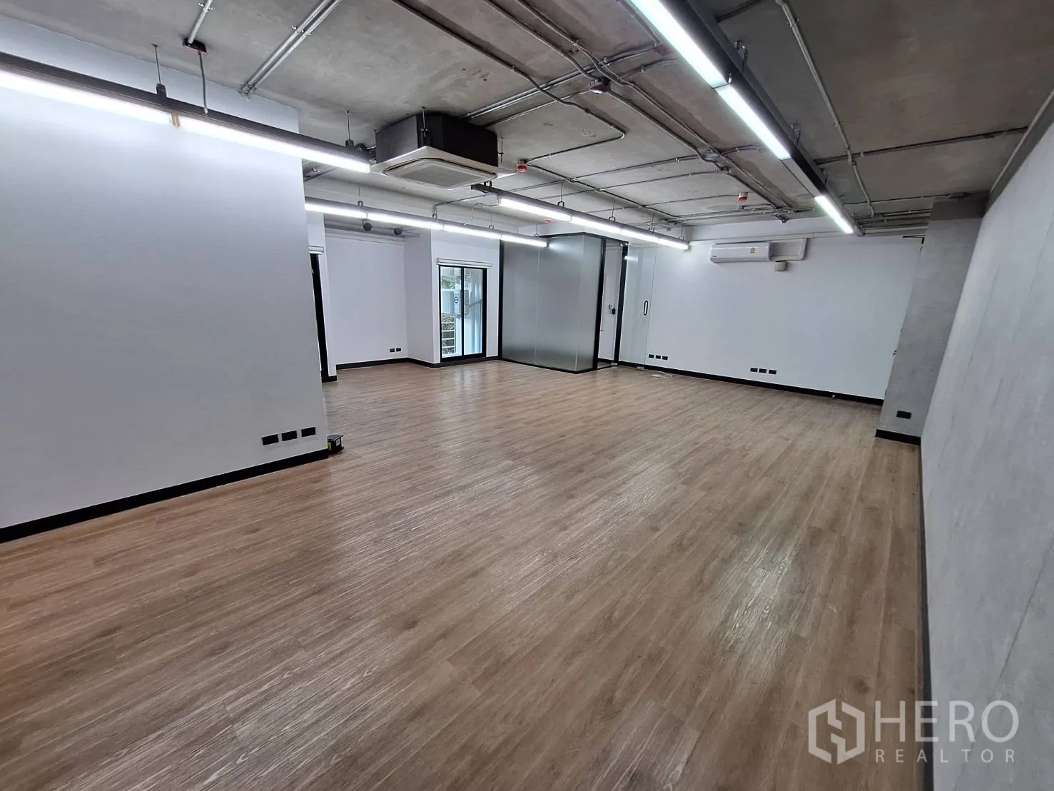 Office Space for rent - Large flexible workspace with light wood floors and linear LED lighting.
