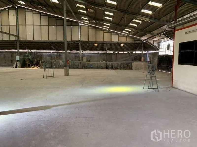 Warehouse for rent - Industrial interior with equipment along walls and generous floor space.