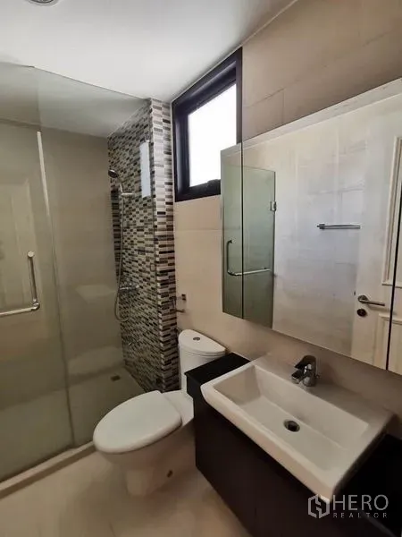 Townhouse for rent in Yan Nawa, Bangkok - Modern bathroom with glass-enclosed shower, mosaic wall tiles, and vanity.