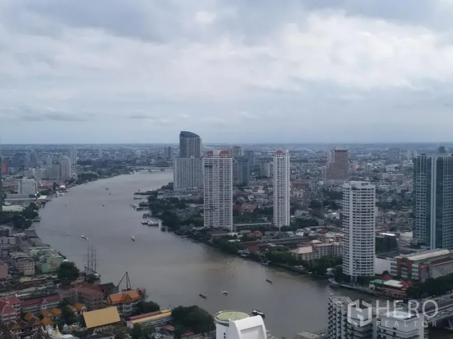 Condominium for rent in Bang Rak, Bangkok - High-floor cityscape and Chao Phraya River view with tall riverside condominiums.
