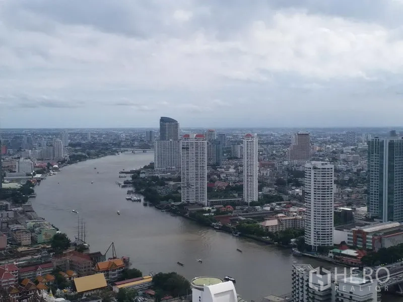 Condominium for rent in Bang Rak, Bangkok - High-floor cityscape and Chao Phraya River view with tall riverside condominiums.