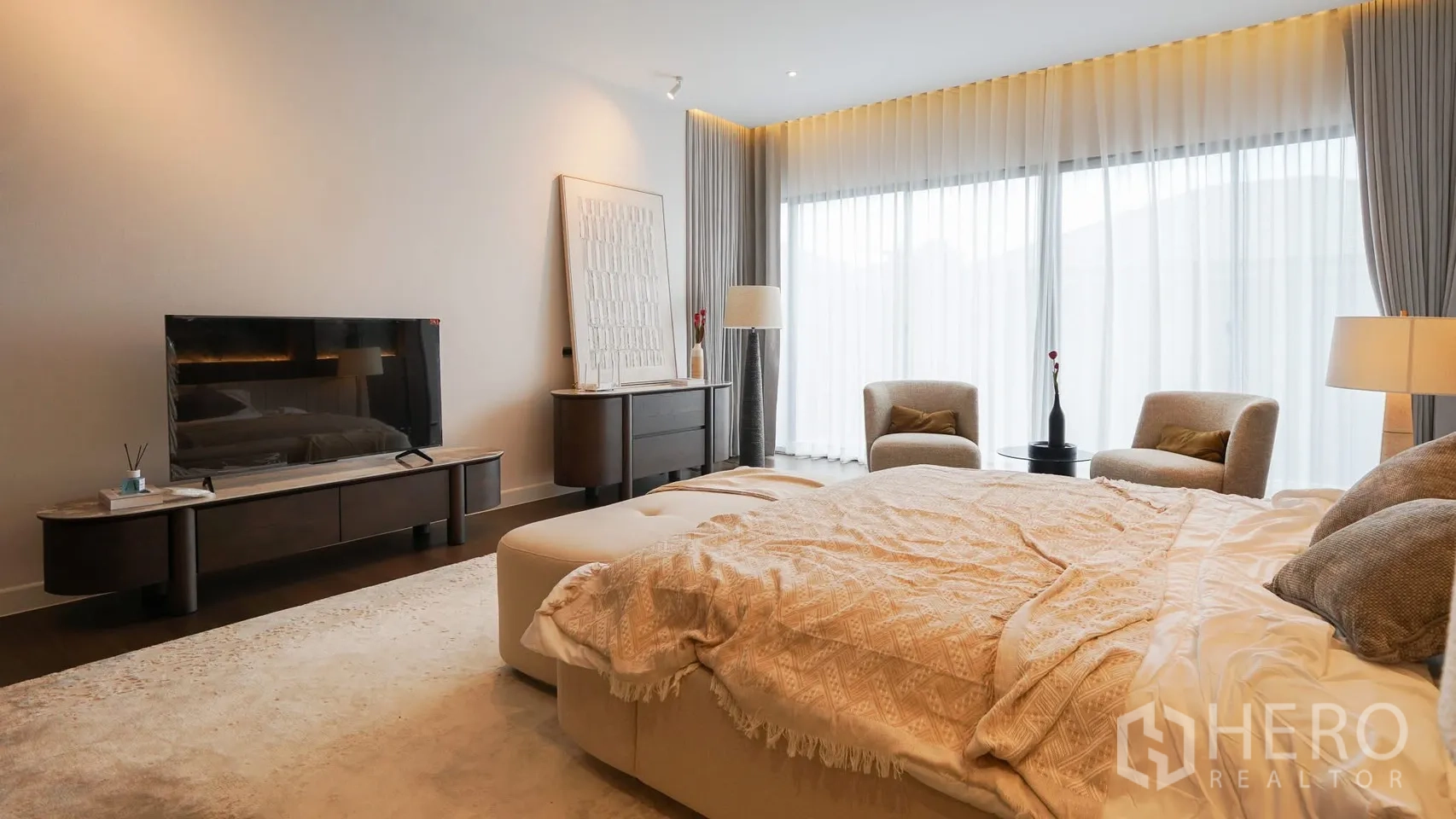 独立式住宅 出租或出售在Bang Kapi, Bangkok - 宽阔主卧套房，带会客区与现代家具及垂落窗帘。