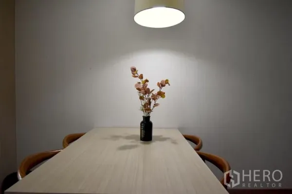 คอนโด ให้เช่าในKhlong Toei, Bangkok - โต๊ะรับประทานอาหารสไตล์มินิมอลพร้อมโคมไฟแขวนและแจกันดอกไม้