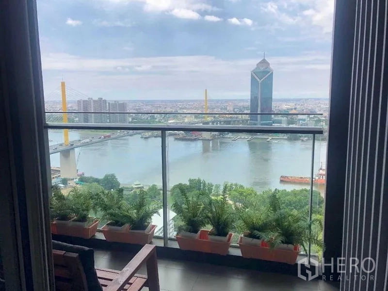 公寓 出租或出售在Bang Kho Laem, Bangkok - 阳台种满绿植，可眺望河流、大桥与曼谷天际线。