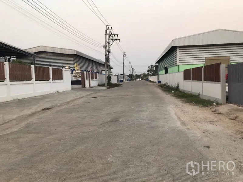 工厂 出售在Pak Kret, Nonthaburi - 厂区前道路，两侧为仓厂与电线杆