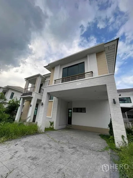 บ้าน ขายในLat Krabang, Bangkok - ด้านนอกบ้านมีโรงจอดรถในร่ม 2 คัน และทางเข้าปูพื้นข้างสวน