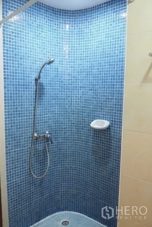 Condominium for rent in Pathum Wan, Bangkok - Blue mosaic-tiled shower corner with handheld shower