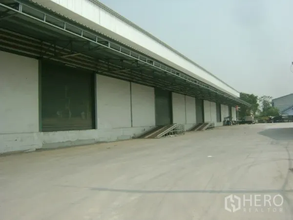 货栈 出租在Mueang Samut Sakhon, Samut Sakhon - 雨棚装卸区前方的宽阔车道，配多樘卷帘门，便于卡车调头。