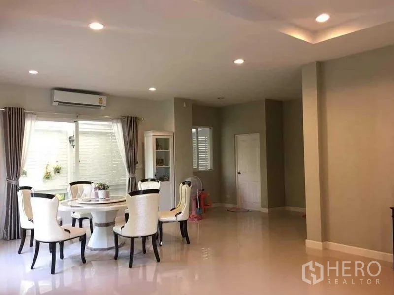 独立式住宅 出售在Bang Kruai, Nonthaburi - 明亮餐区，圆桌、嵌灯与窗帘。