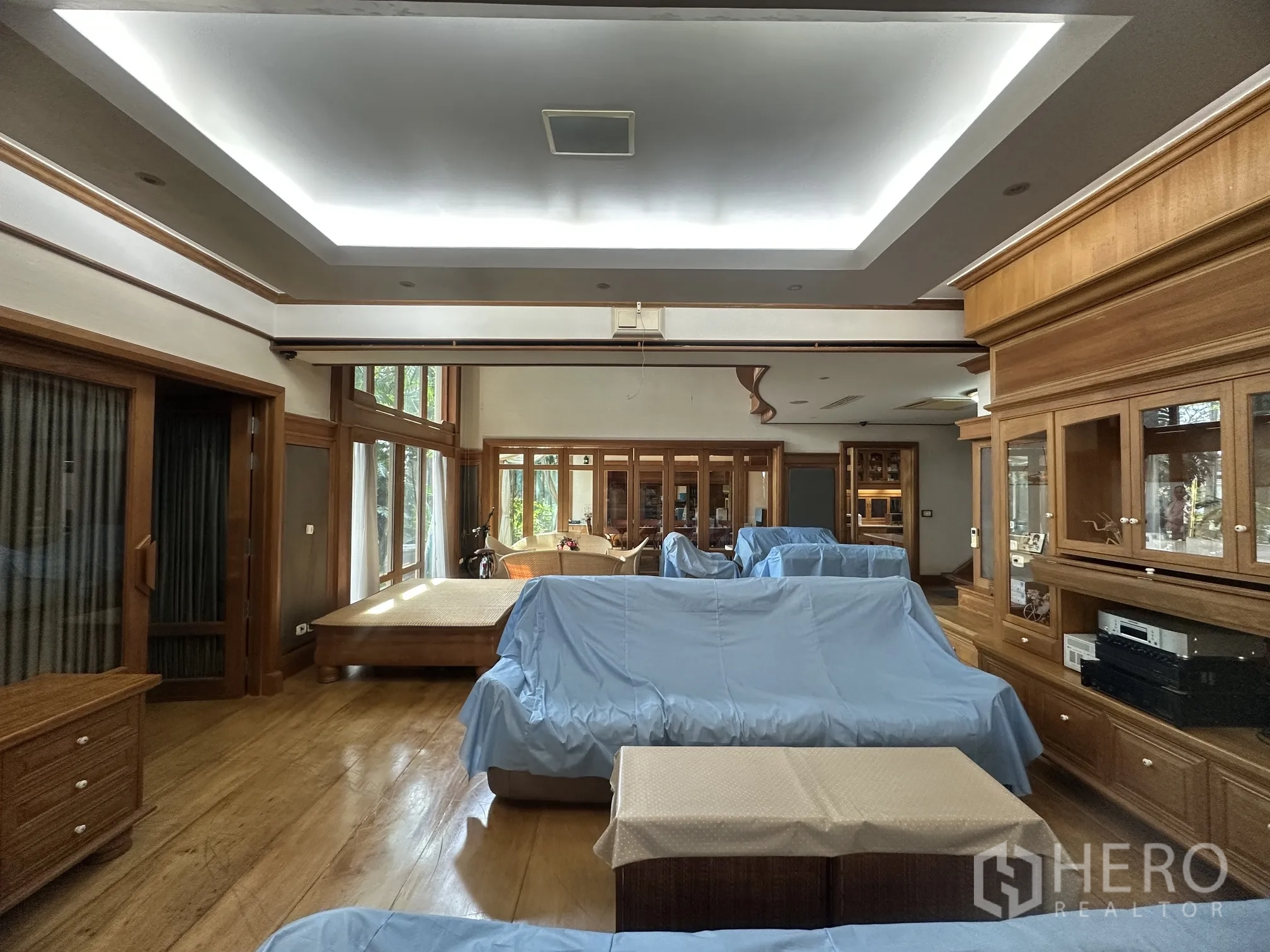 Detached House for rent in Lam Luk Ka, Pathum Thani - Lounge with recessed ceiling lighting, wood flooring, and built-in display units.