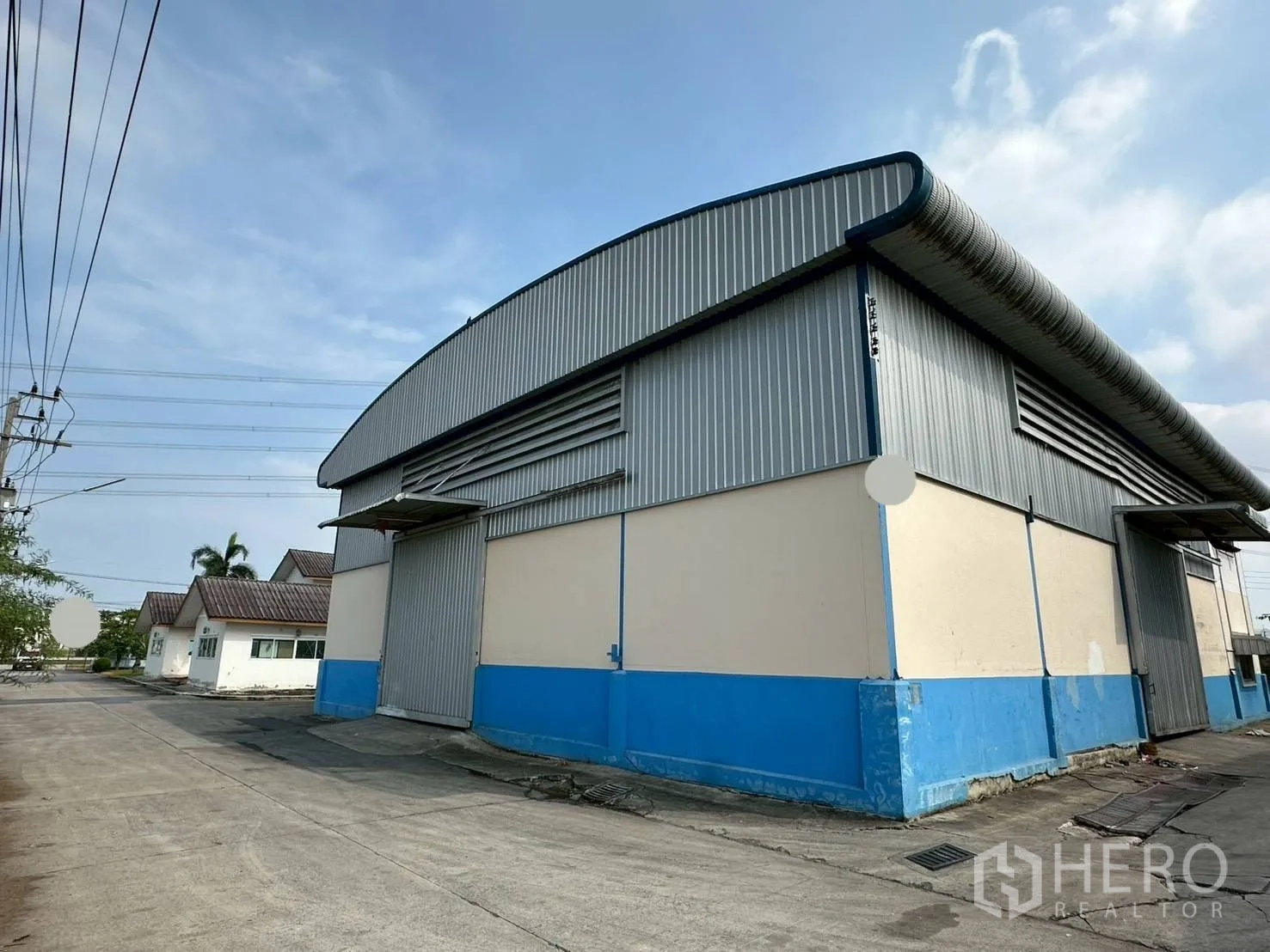 工厂 出租在Lat Lum Kaeo, Pathum Thani - 安保园区内蓝米色工厂外观，金属波纹板立面转角视角。