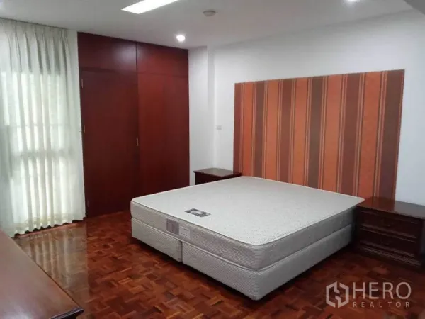 คอนโด ให้เช่าในWatthana, Bangkok - ห้องนอนหลักมีหัวเตียงลายทาง ตู้เสื้อผ้าบิวท์อิน และพื้นปาร์เกต์