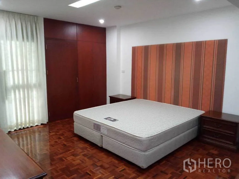 คอนโด ให้เช่าในWatthana, Bangkok - ห้องนอนหลักมีหัวเตียงลายทาง ตู้เสื้อผ้าบิวท์อิน และพื้นปาร์เกต์