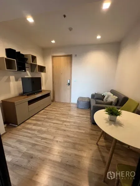 公寓 出租在Chatuchak, Bangkok - 现代客厅，木地板，电视柜、壁挂格架、沙发与用餐角落，位于恰图恰克公寓内。