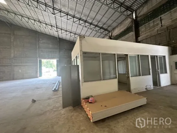 Warehouse for rent in Suan Luang, Bangkok - Internal office cabin with glass panels inside a high-clearance warehouse.