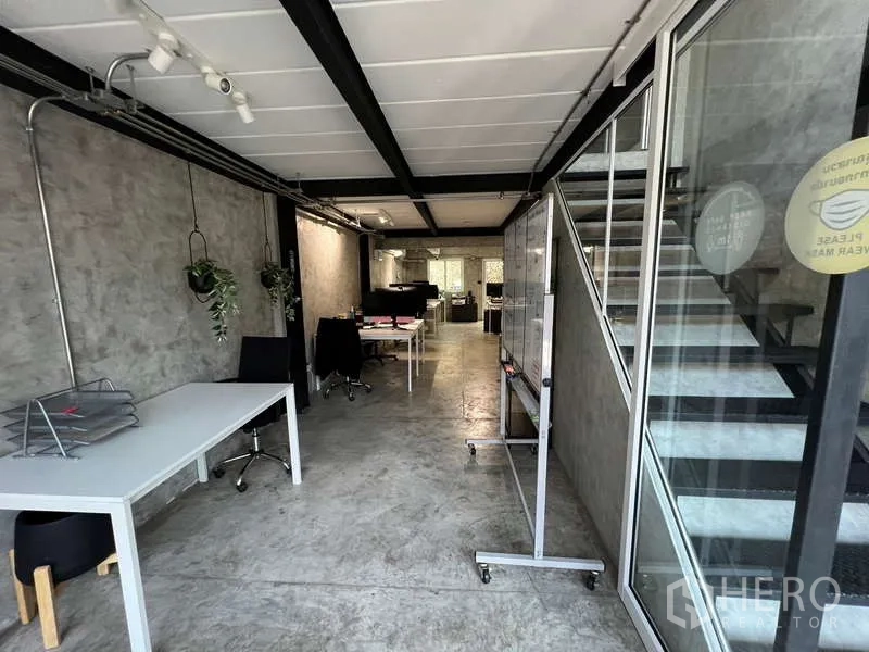 อาคารพาณิชย์ ขายในSuan Luang, Bangkok - พื้นที่ทำงานชั้นล่างติดผนังกระจก มีโต๊ะทำงานและบันไดเหล็ก