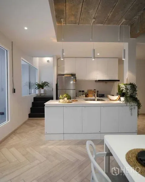ทาวน์เฮาส์ ให้เช่าในWatthana, Bangkok - ครัวสไตล์โมเดิร์นสีขาวพร้อมไอส์แลนด์ โคมไฟแขวน และตู้บิลท์อินใกล้บันได