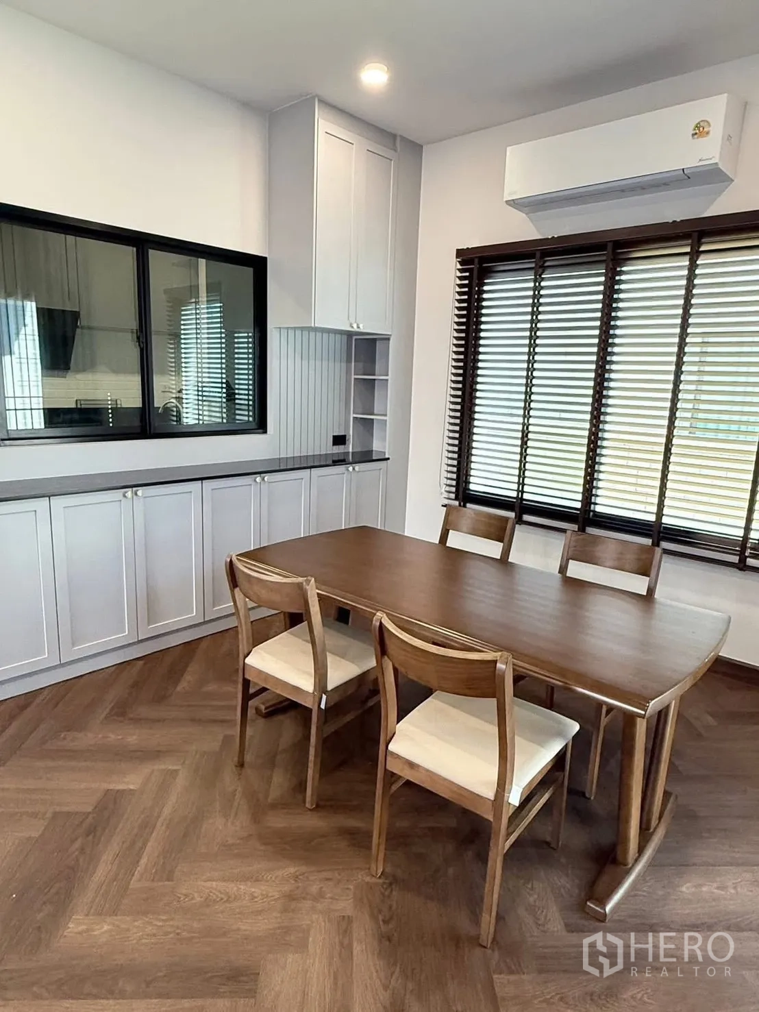 Detached House for rent in Bang Phli, Samut Prakan - Dining room with wooden table for six, cabinets and window blinds.