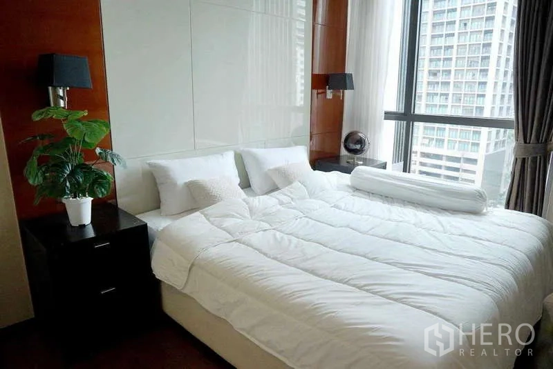 公寓 出租或出售 - 采光充足的卧室，特大床与落地窗城市景观。