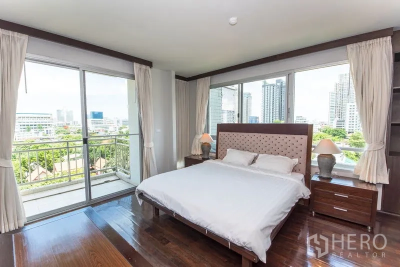 Condominium for rent in Sathon, Bangkok - Master bedroom with balcony access and large windows overlooking the Bangkok skyline.