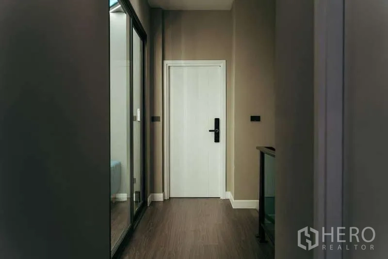 บ้าน ขายในSai Mai, Bangkok - โถงชั้นบนปูพื้นไม้ ประตูสีขาว และผนังกระจก