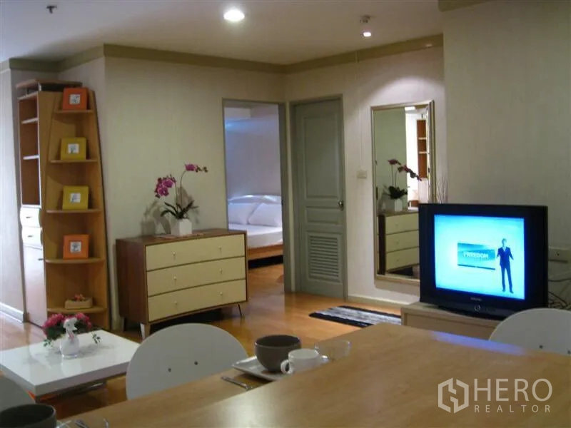 คอนโด ให้เช่าในKhlong Toei, Bangkok - มุมเคาน์เตอร์รับประทานอาหารมองไปยังโซนทีวี พร้อมตู้เก็บของและประตูสู่ห้องนอน