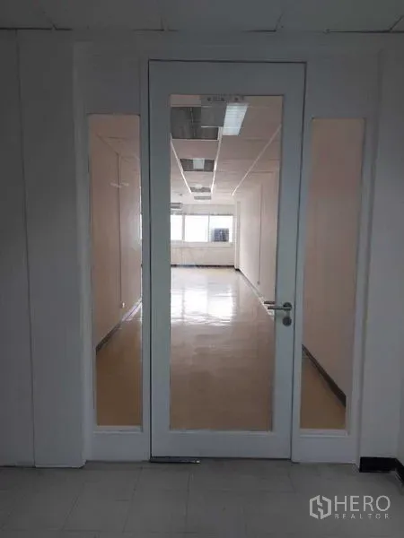办公空间 出租在Pathum Wan, Bangkok - 带侧边玻璃的入户玻璃门，通向明亮的开放式办公区。