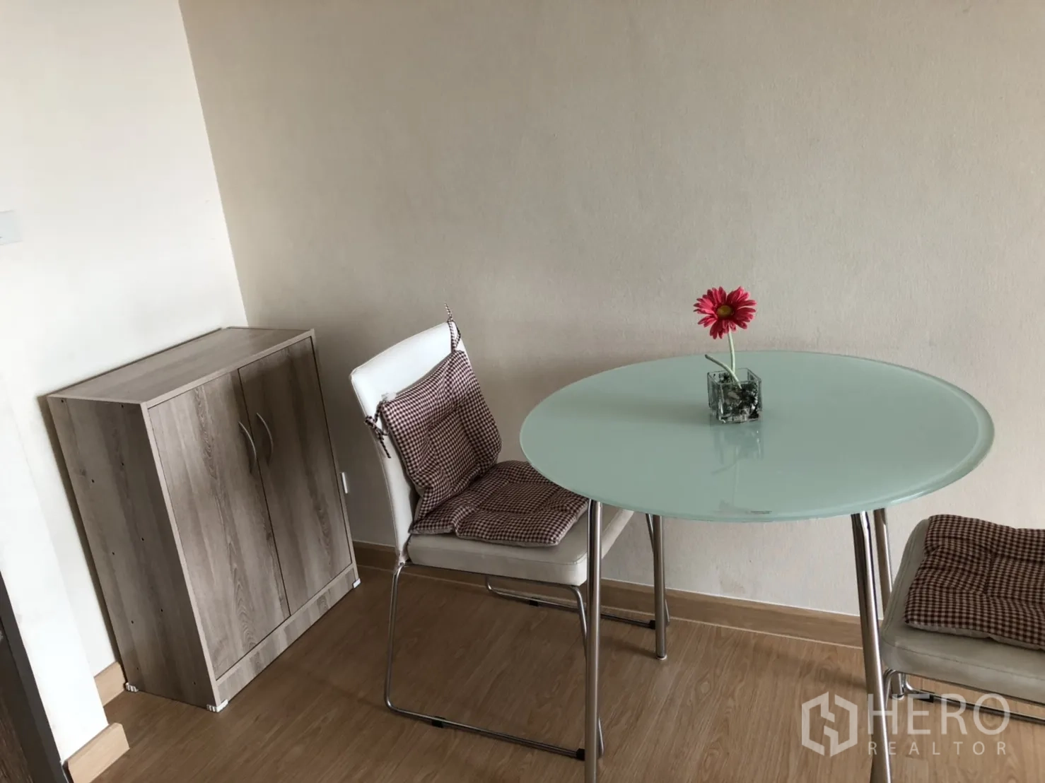 公寓 出租在Khlong Toei, Bangkok - 小型用餐角落，圆形玻璃餐桌、两把座椅与木质小柜。