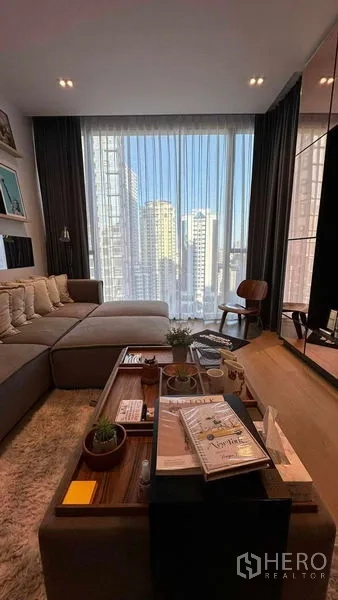 Condominium for sale - Cozy seating area with coffee table and tall curtains framing a skyline view.