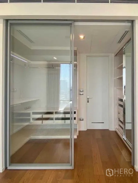 Condominium for rent in Sathon, Bangkok - Walk-in closet and dressing area with wood flooring and mirrored storage.