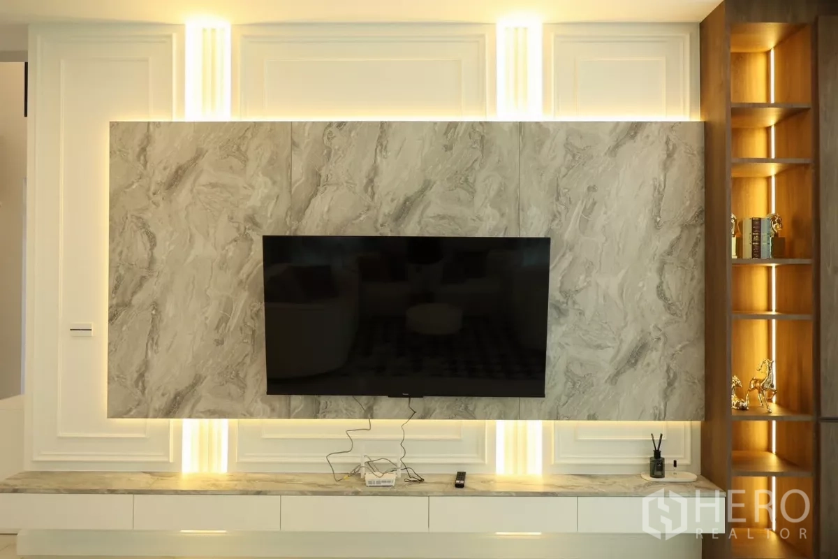 Detached House for rent or sale in Saphan Sung, Bangkok - Feature wall with marble panels, accent lighting, and mounted flat-screen TV.