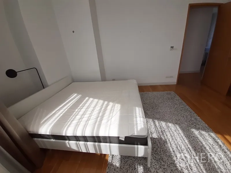 คอนโด ให้เช่าในKhlong Toei, Bangkok - ห้องนอนหลักมองไปทางประตู พื้นไม้และพรมปูพื้น