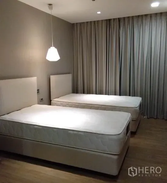 อพาร์ทเมนท์ ให้เช่าในKhlong Toei, Bangkok - ห้องนอนที่สอง เตียงเดี่ยวสองเตียง โคมไฟแขวน และผ้าม่านทึบแสง