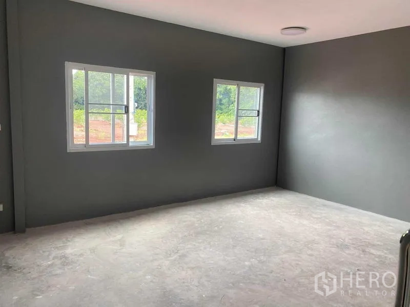 คลังสินค้า ให้เช่าในBang Bon, Bangkok - ห้องออฟฟิศสว่าง มีหน้าต่างบานเลื่อนสองบาน ผนังสีเทา และพื้นคอนกรีต