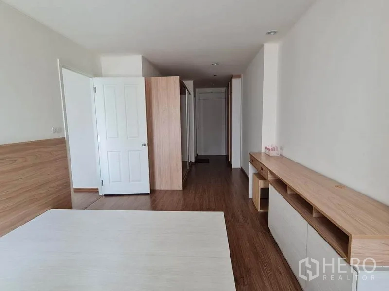 公寓 出租或出售在Yan Nawa, Bangkok - 宽敞主卧，长型内置柜与木质墙面，连接走廊动线顺畅。