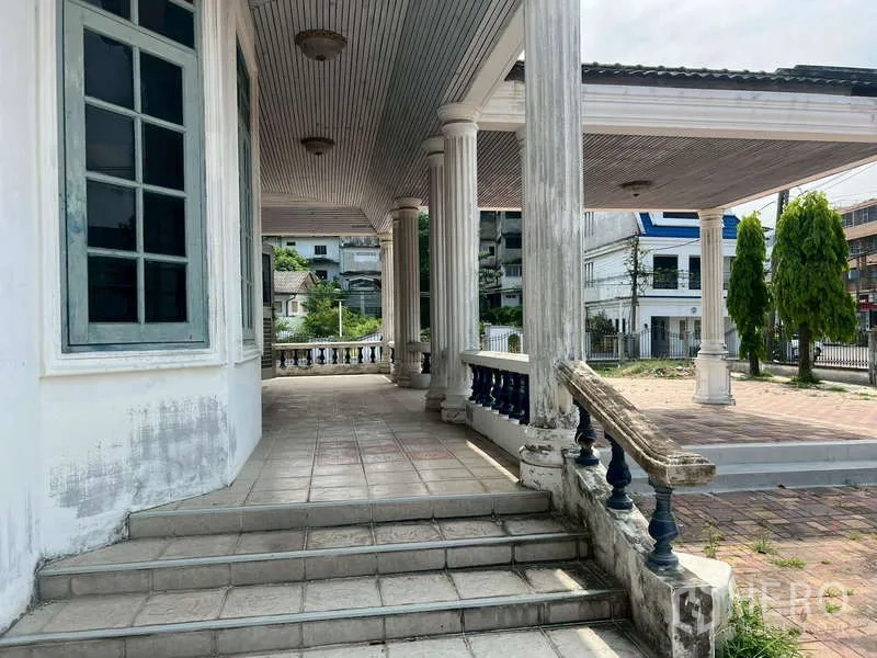 Detached House for rent in Prawet, Bangkok - Side porch with steps and classic columns facing the street.