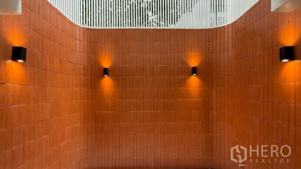 Home Office for rent in Watthana, Bangkok - Curved terracotta courtyard wall with modern wall lights and open top for airflow.