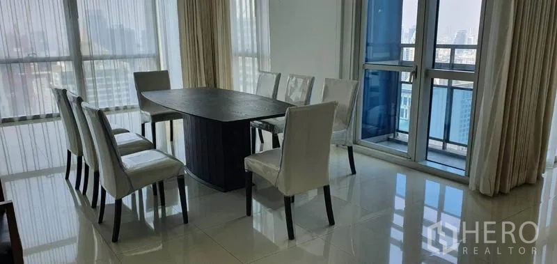 คอนโด ให้เช่าในPathum Wan, Bangkok - โต๊ะอาหารข้างประตูกระจกและระเบียงพร้อมวิวสกายไลน์