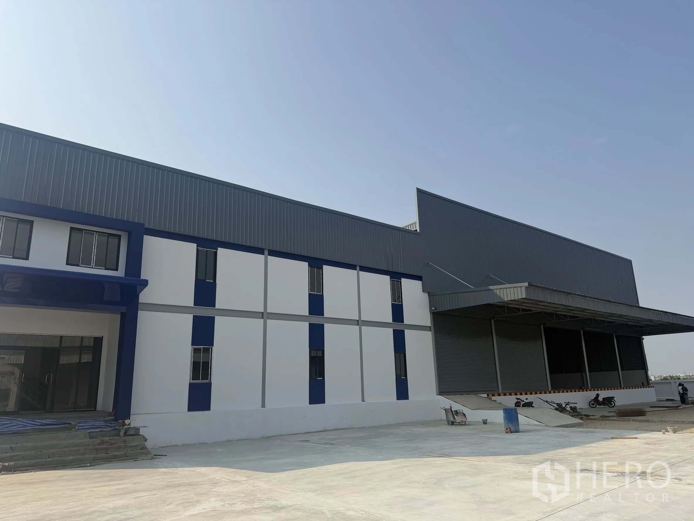 Warehouse for rent in Bang Bo, Samut Prakan - Side perspective of the warehouse exterior and sheltered loading dock.