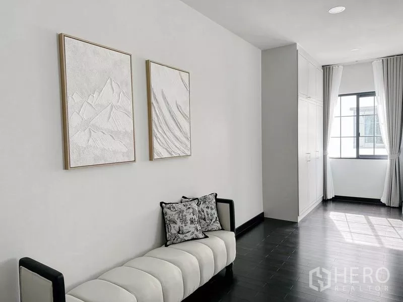 Detached House for rent or sale in Bang Phli, Samut Prakan - Hall sitting area with wall art, built-in cabinetry and natural light from the window.