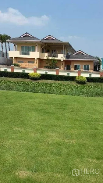 บ้าน ขายในPrawet, Bangkok - สนามหญ้ากว้างและแนวพุ่มไม้หน้าบ้านสองชั้น