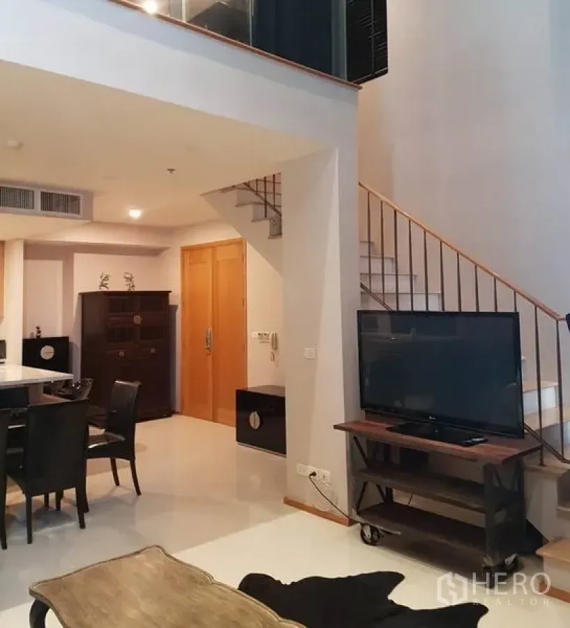 คอนโด ให้เช่าหรือขายในKhlong Toei, Bangkok - พื้นที่นั่งเล่นแบบดูเพล็กซ์พร้อมบันได ชั้นวางทีวี และโต๊ะทานอาหาร