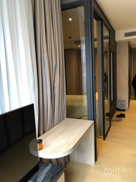 คอนโด ให้เช่าในDin Daeng, Bangkok - ฉากกั้นกระจกระหว่างห้องนั่งเล่นกับห้องนอน พร้อมผ้าม่านและงานไม้โทนอ่อน