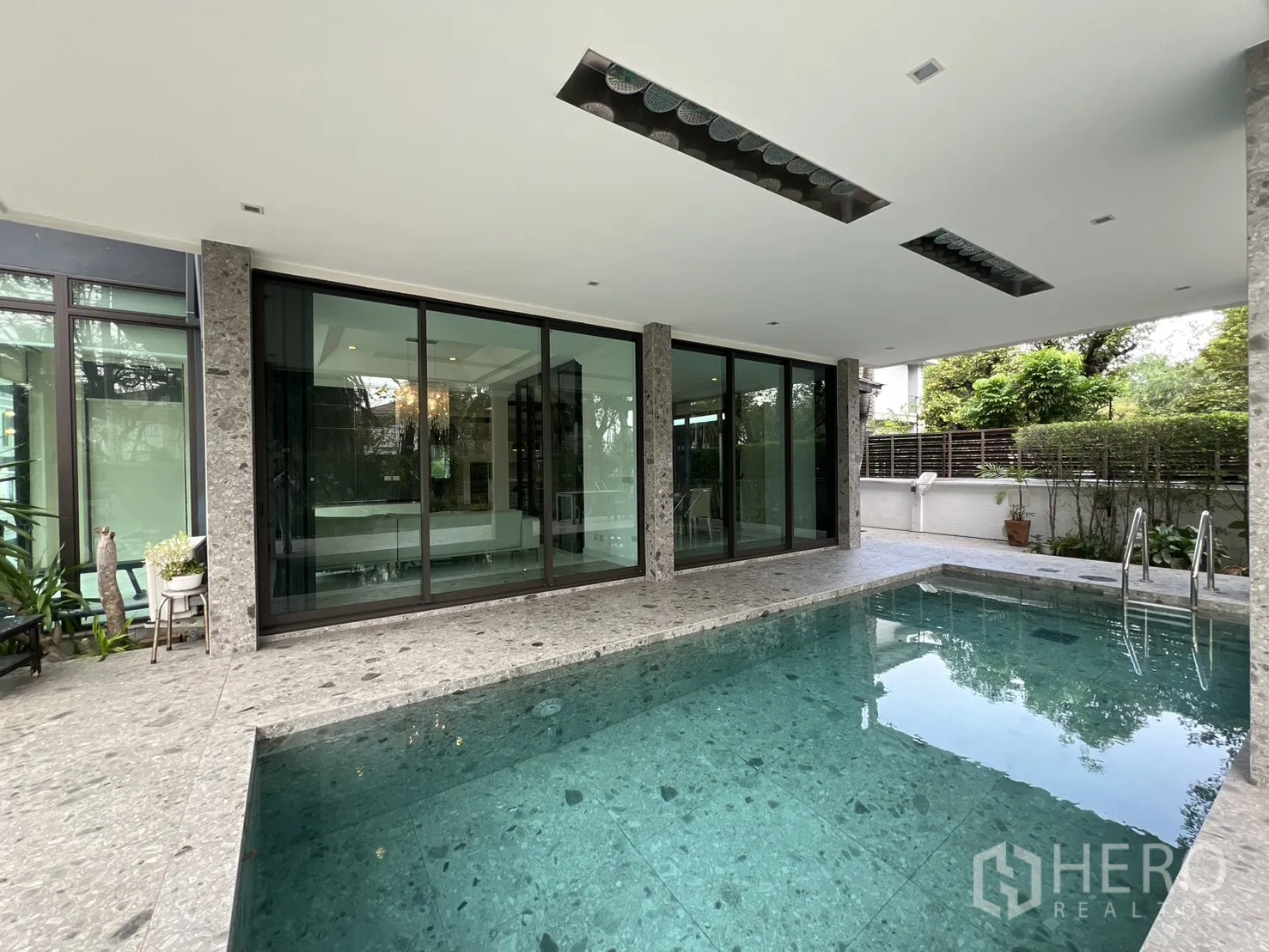 独栋房屋 for rent in Prawet, Bangkok - 泳池紧邻落地玻璃，可望见室内起居空间。