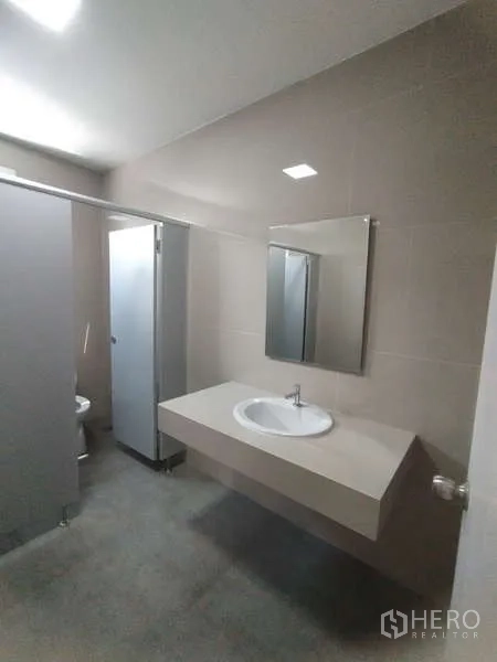 Warehouse for rent in Bang Pakong, Chachoengsao - Restroom sink and mirror with tiled walls inside the facility.