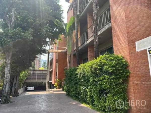 อพาร์ทเมนท์ ให้เช่า - อาคารอพาร์ตเมนต์อิฐแดงโลวไรส์ มีระเบียง ทางเข้า และต้นไม้ใหญ่