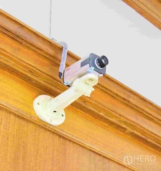 Office Space for rent in Lak Si, Bangkok - Ceiling-mounted CCTV security camera on a wooden beam inside the office building.